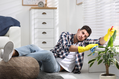 Photo of Lazy man procrastinating while cleaning at home