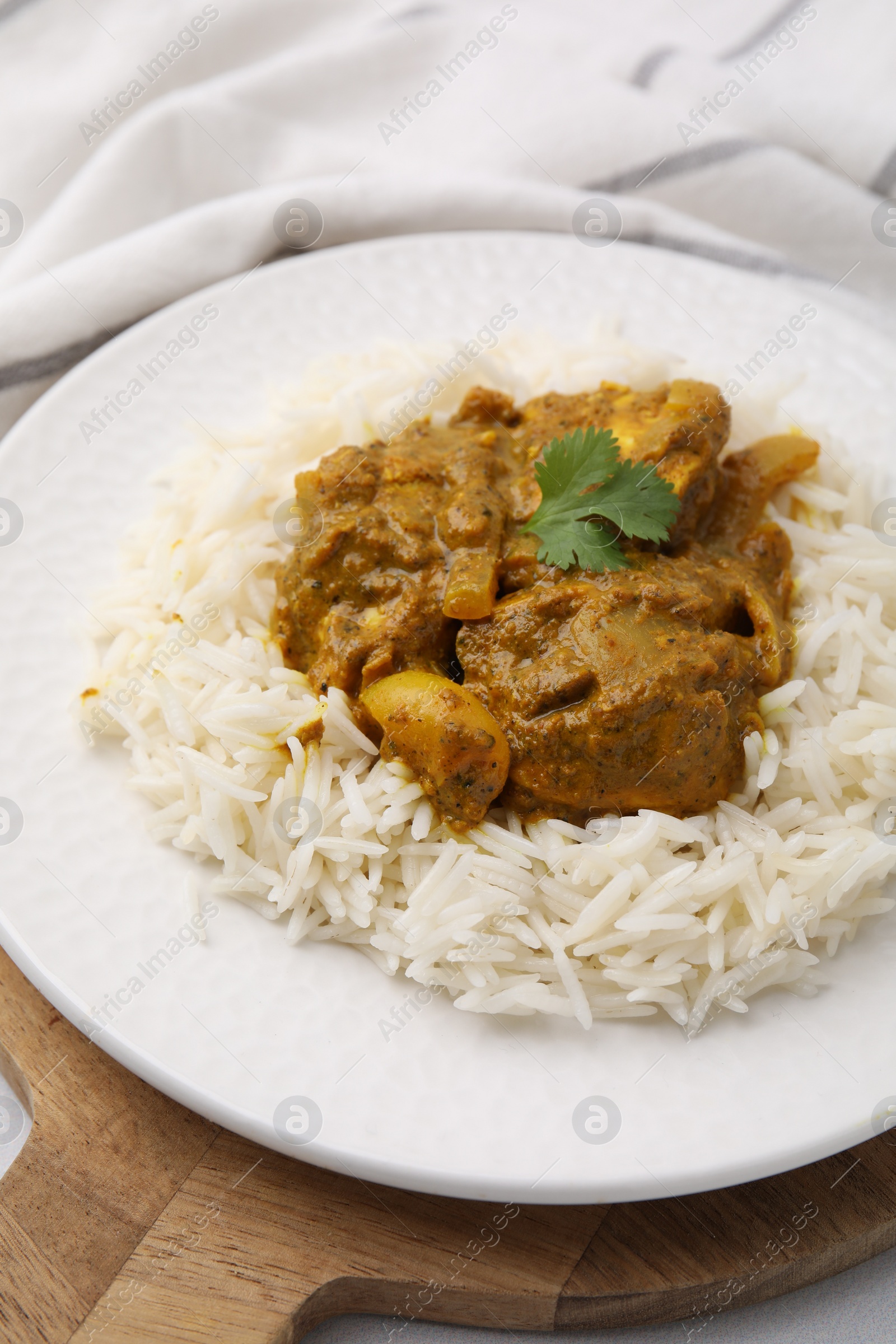 Photo of Delicious chicken curry with rice on table, closeup