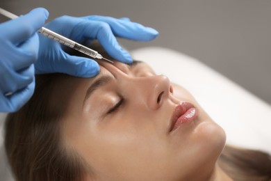 Photo of Beautiful woman getting facial injection in salon, closeup