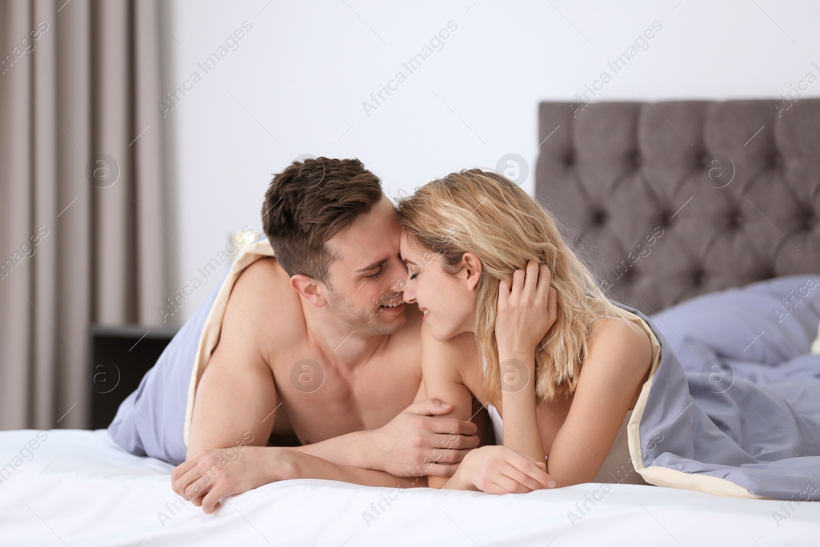 Photo of Sexy young couple being intimate in bed at home