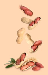 Image of Fresh unpeeled peanuts falling on beige background