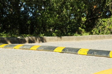Photo of Speed bump on asphalt road near trees outdoors
