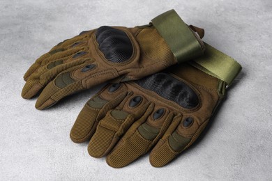 Tactical gloves on light gray background. Military training equipment
