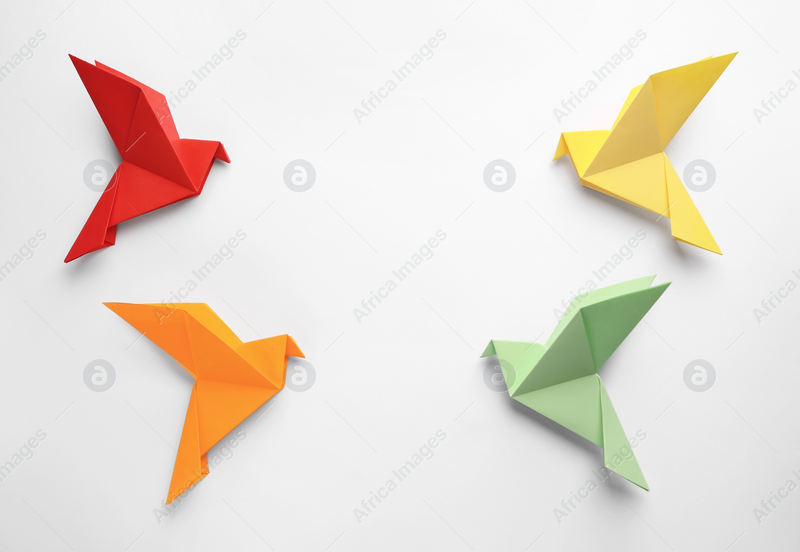Photo of Origami art. Colorful handmade paper birds on white background, flat lay. Space for text