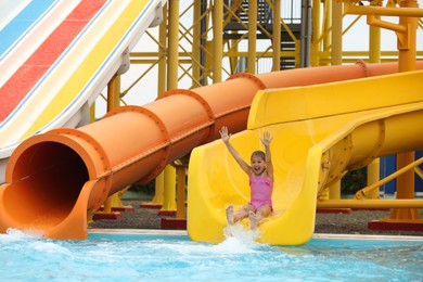Photo of Cute little girl on slide in water park
