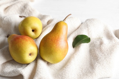 Photo of Ripe pears on light fabric. Healthy snack