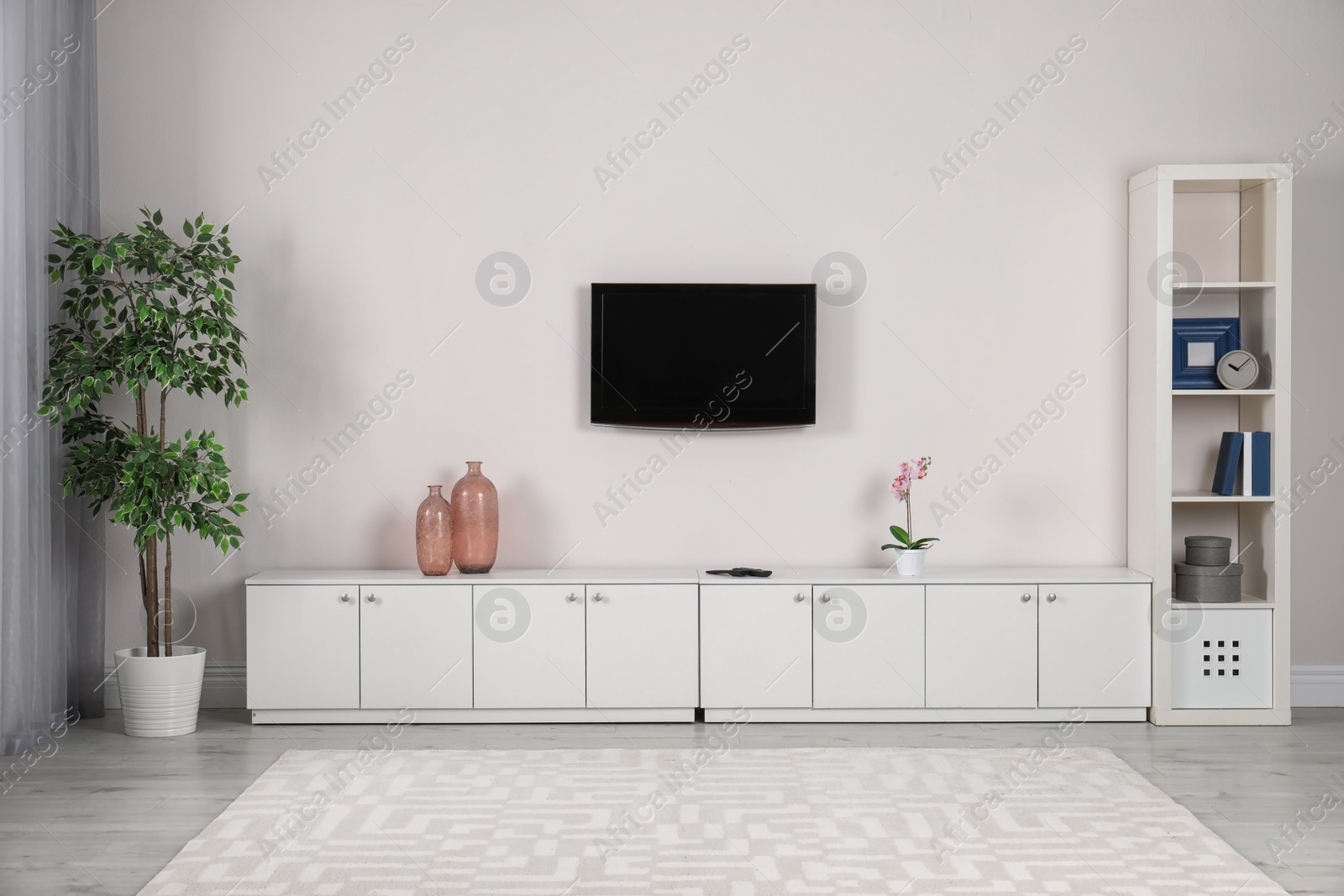 Photo of Modern TV set mounted on wall in living room