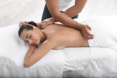 Relaxed woman receiving back massage in wellness center