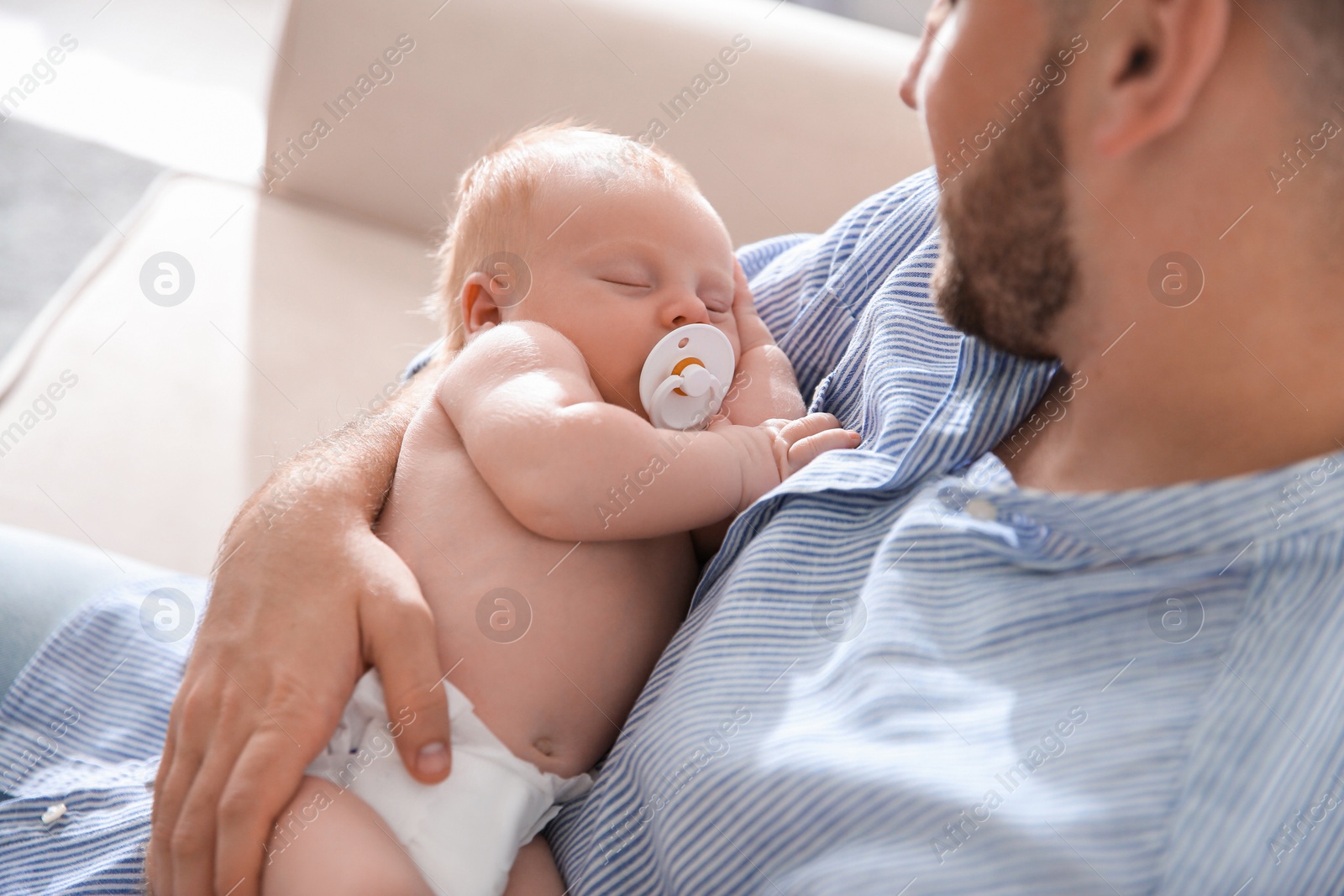 Photo of Father with his newborn son at home, closeup