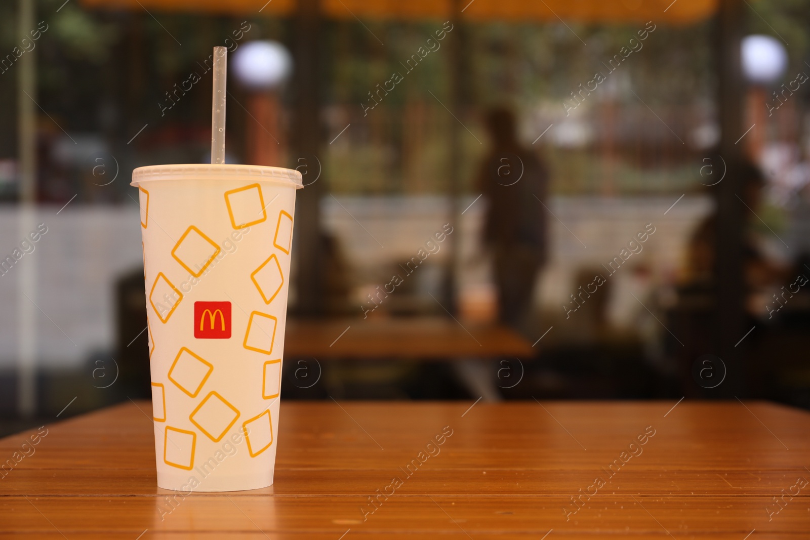 Photo of MYKOLAIV, UKRAINE - AUGUST 11, 2021: Cold McDonald's drink on table in cafe. Space for text