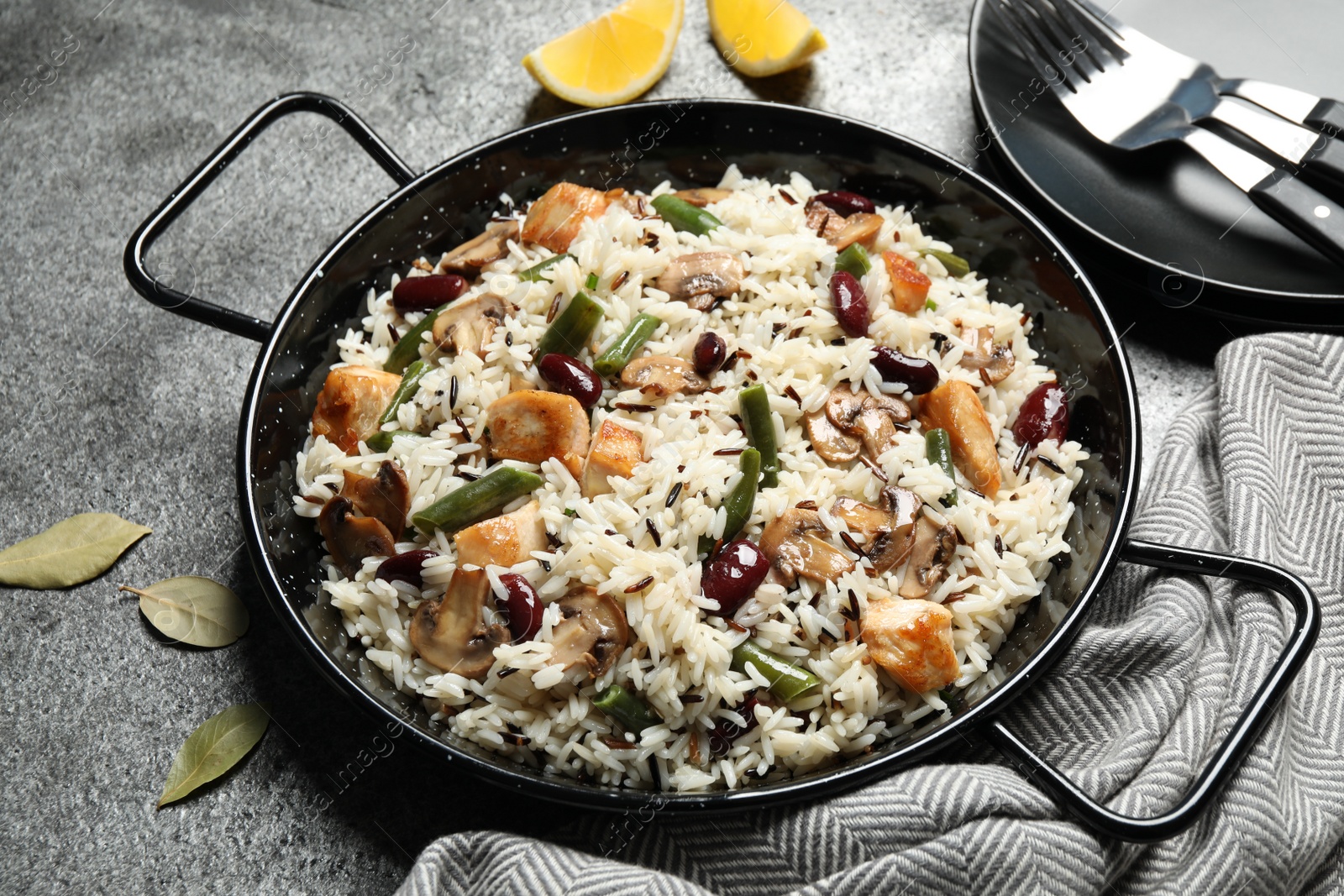 Photo of Delicious rice pilaf with chicken and vegetables on grey table