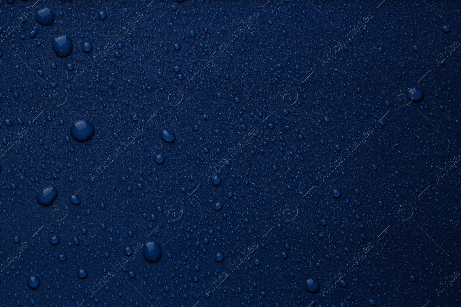 Photo of Many water drops on bright blue background