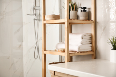 Photo of Shelving unit with clean towels in bathroom interior