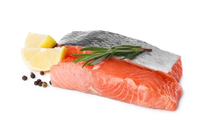 Pieces of fresh raw salmon, spices and lemon slices on white background