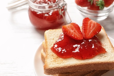 Photo of Tasty toast bread with strawberry jam and fresh berries on light background, closeup