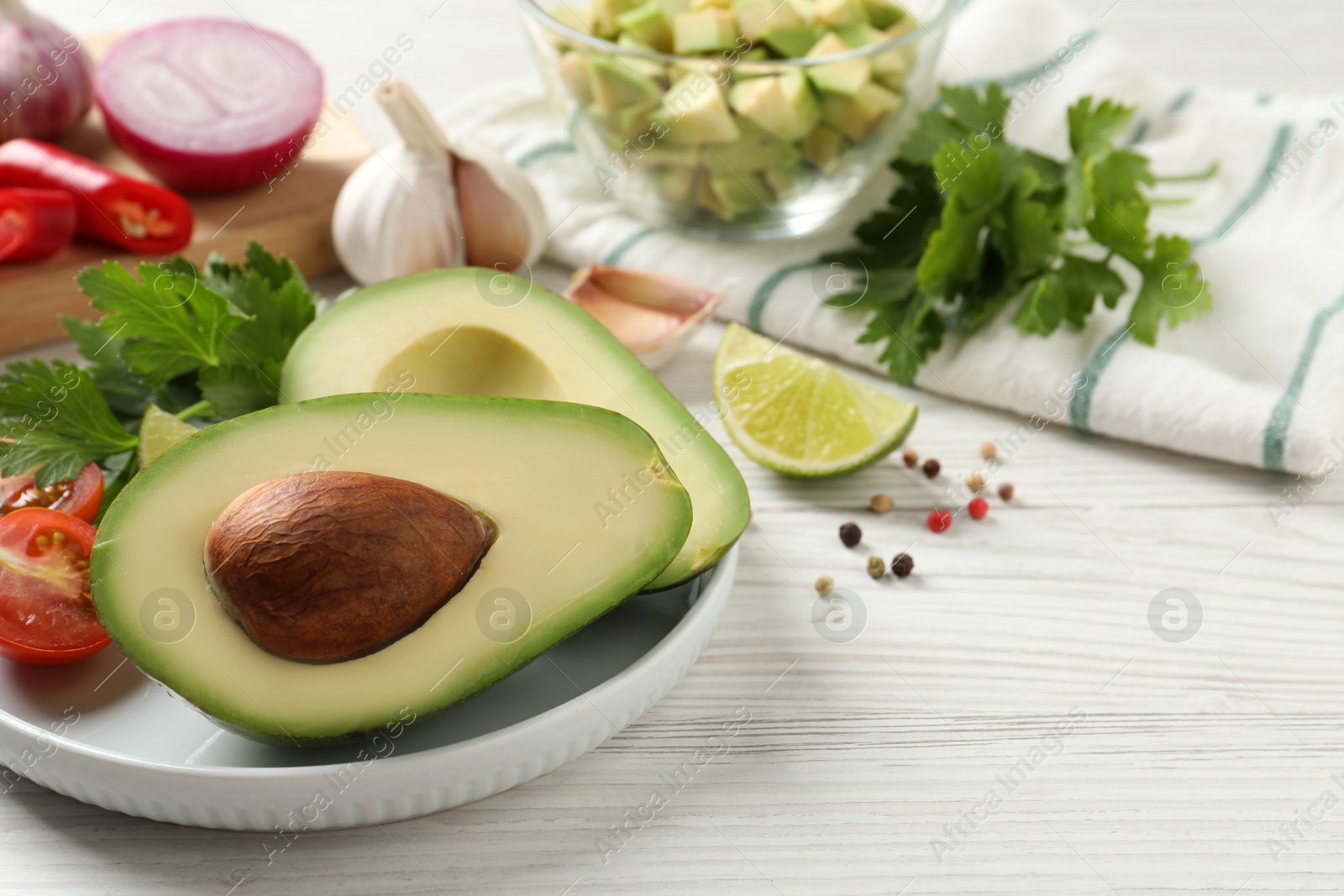 Photo of Fresh ingredients for guacamole on white wooden table