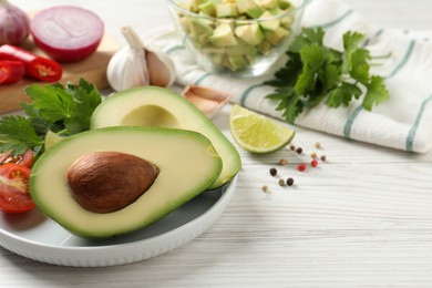 Fresh ingredients for guacamole on white wooden table