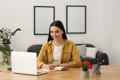 Photo of Woman studying on laptop at home. Online translation course