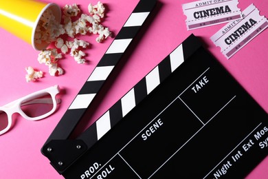 Photo of Flat lay composition with clapperboard and popcorn on pink background