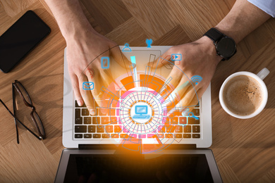 Image of Man working with laptop at wooden table, top view. Modern technology concept