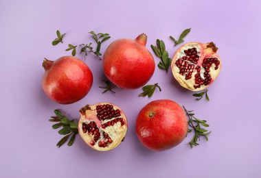 Photo of Flat lay composition with ripe pomegranates on violet background