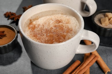 Photo of Delicious eggnog with anise and cinnamon on grey table