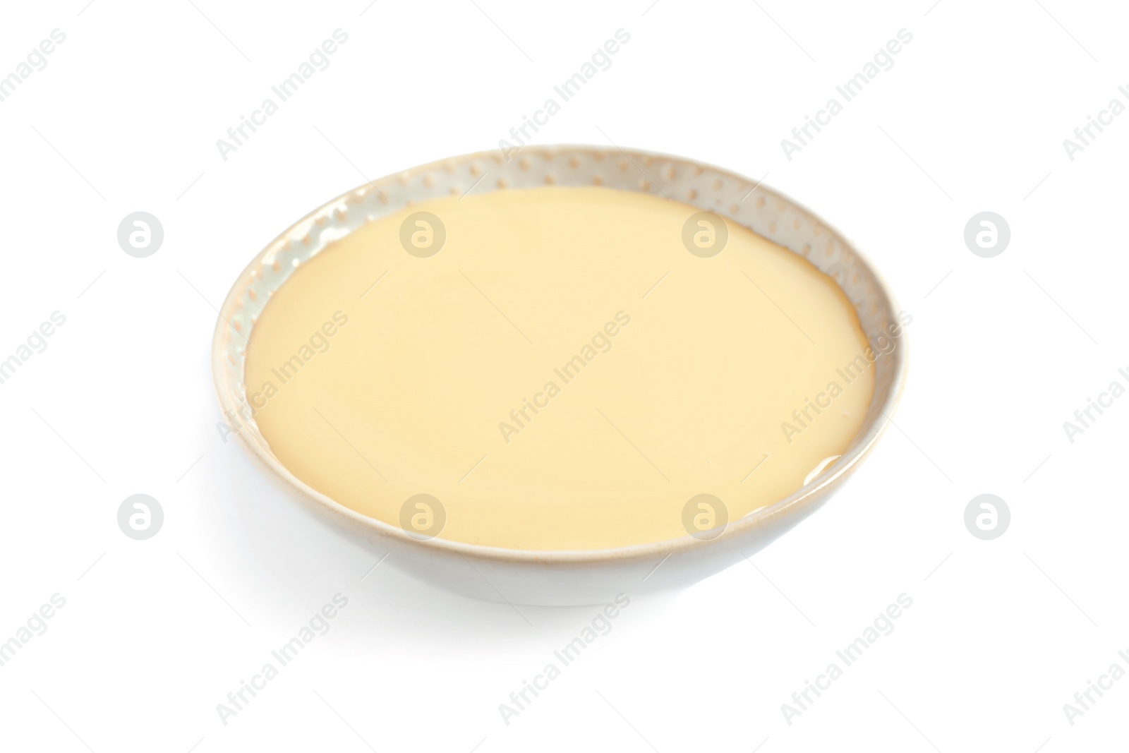 Photo of Bowl with condensed milk on white background. Dairy product