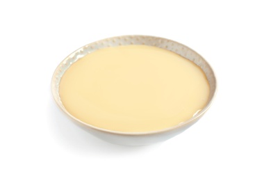 Bowl with condensed milk on white background. Dairy product