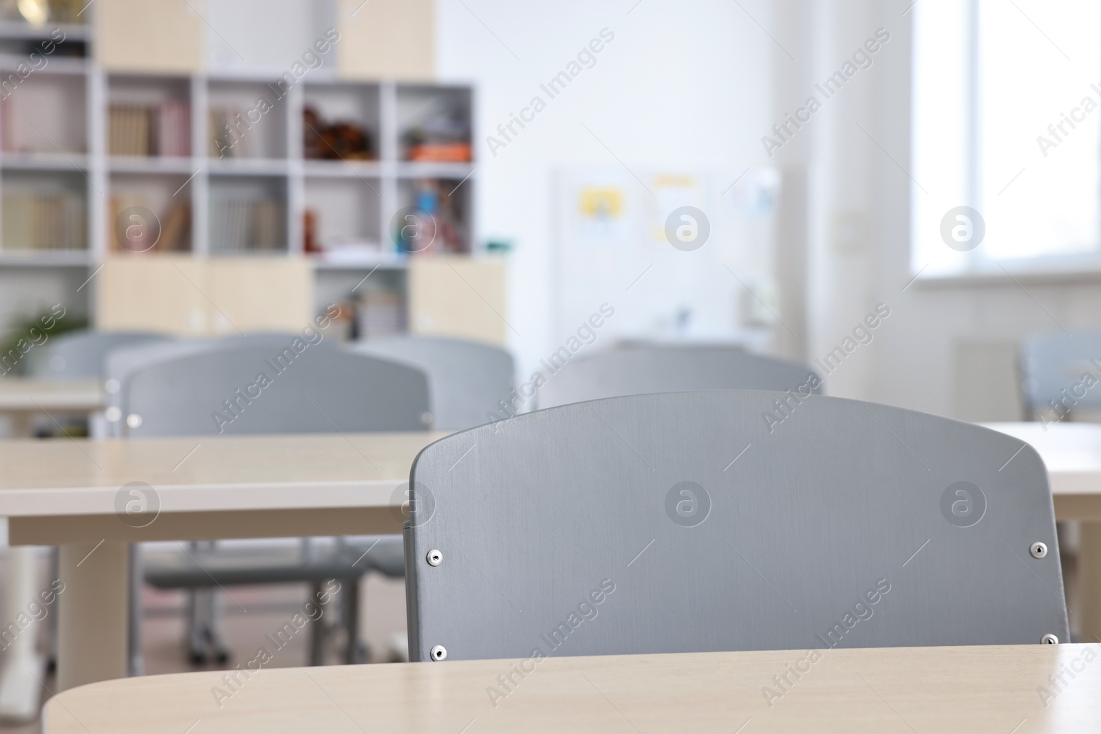 Photo of Empty school classroom with desks and chairs