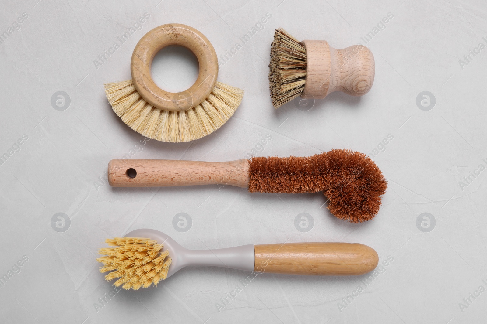 Photo of Cleaning brushes on white table, flat lay