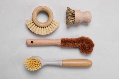 Photo of Cleaning brushes on white table, flat lay