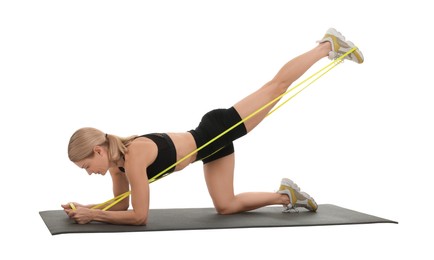 Woman exercising with elastic resistance band on fitness mat against white background