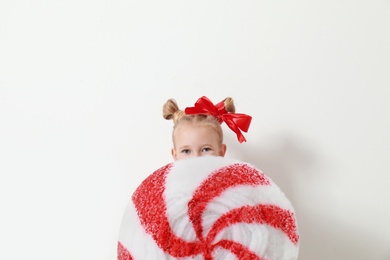 Cute little girl dressed as candy on white background. Christmas suit