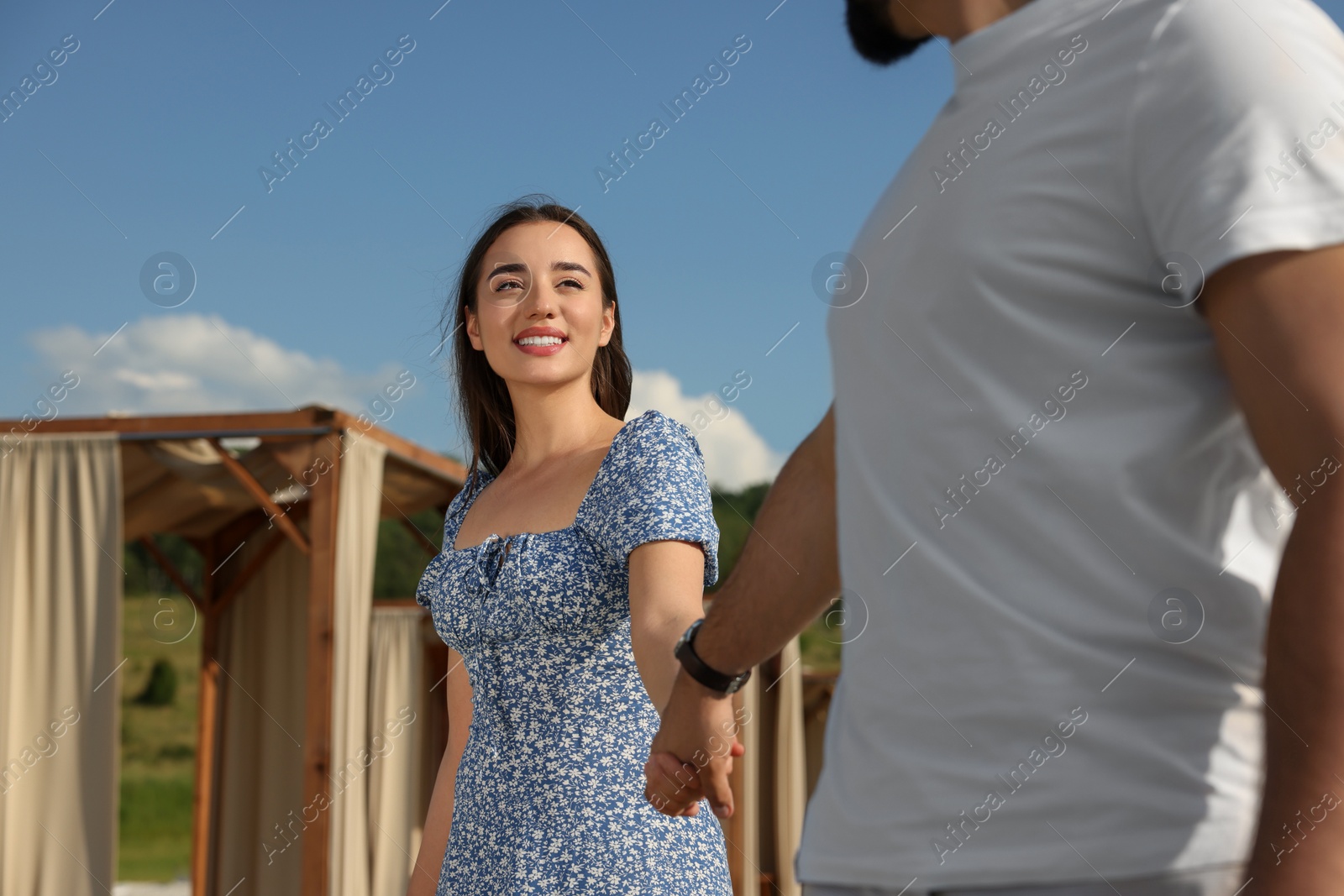 Photo of Romantic date. Beautiful couple walking outdoors on sunny day