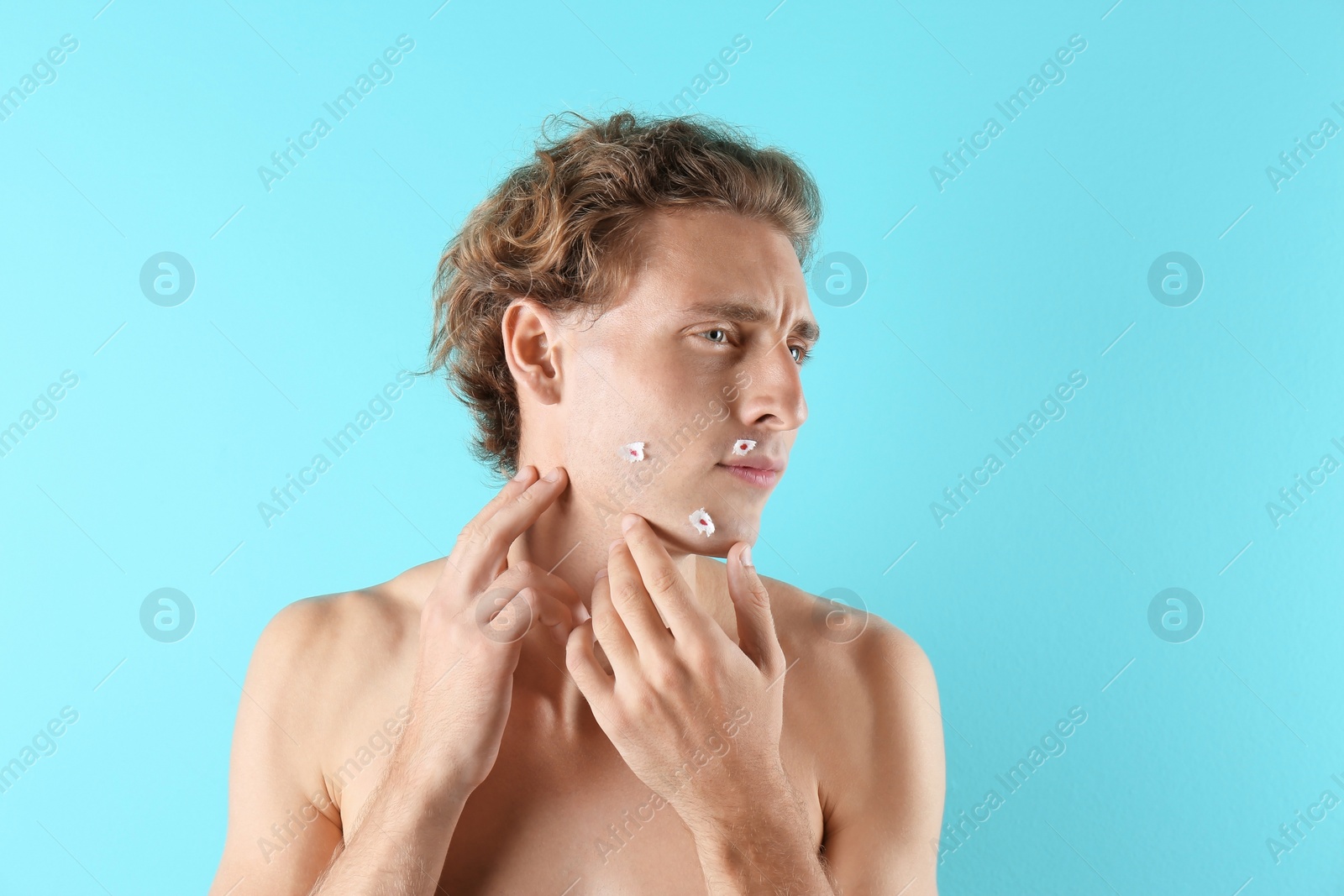 Photo of Young man with face hurt while shaving on color background