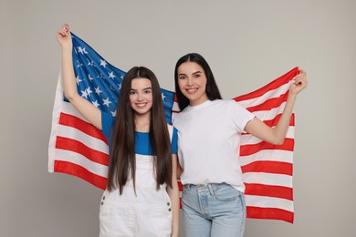 4th of July - Independence Day of USA. Happy woman and her daughter with American flag on light grey background