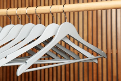 Photo of Empty hangers on rail against wooden background