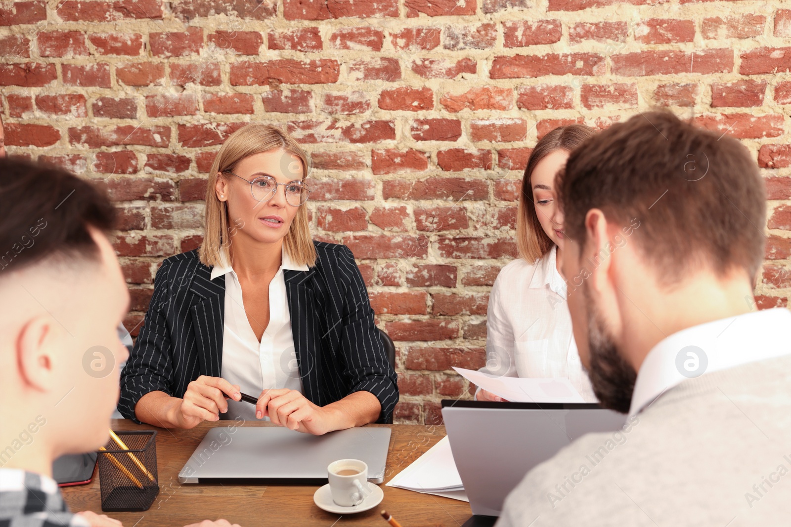 Photo of Businesswoman having meeting with her employees in office. Lady boss