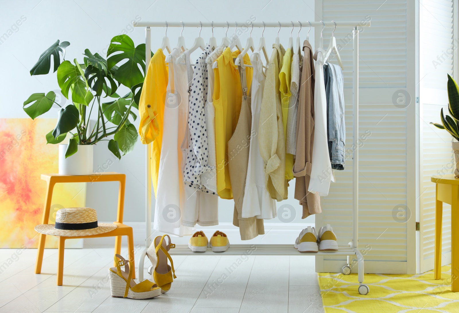 Photo of Dressing room interior with clothing rack and houseplants