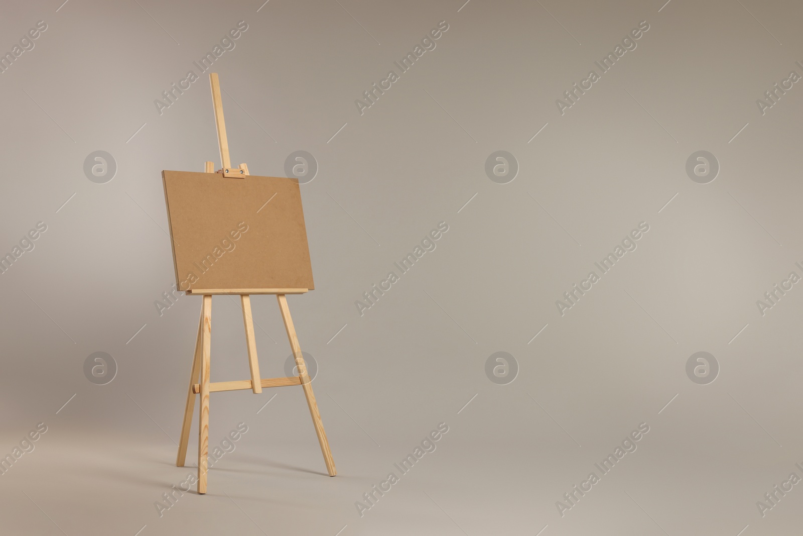 Photo of Wooden easel with blank board on grey background. Space for text