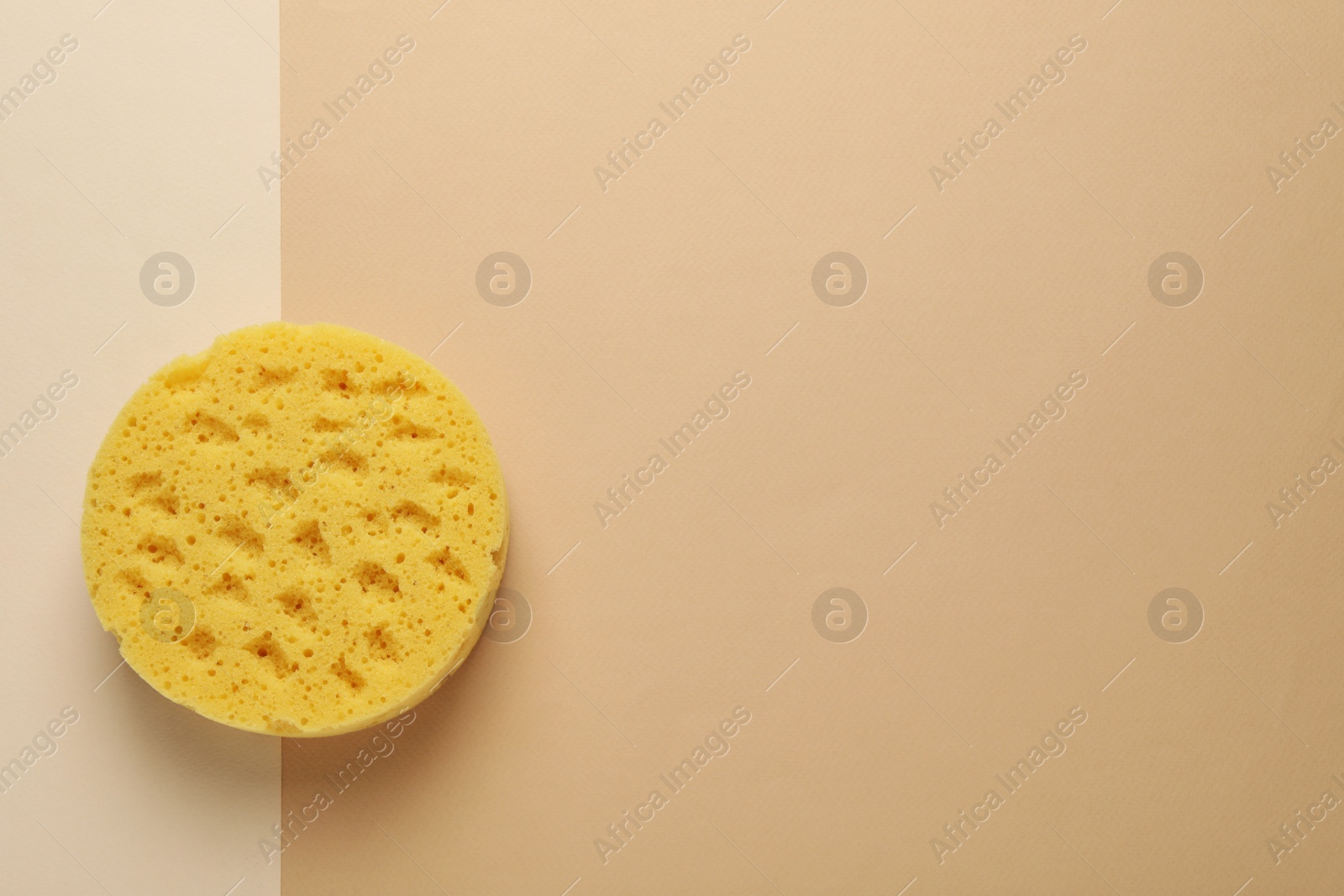 Photo of New sponge on beige background, top view. Space for text