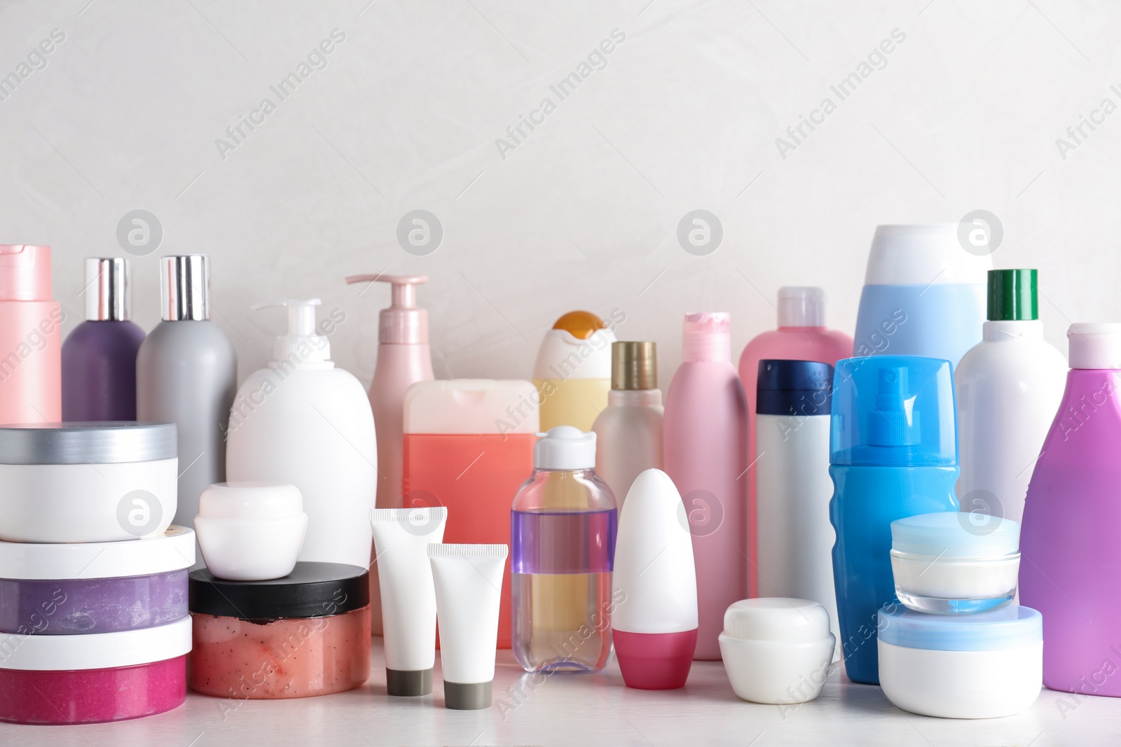 Photo of Different body care products on table against light background