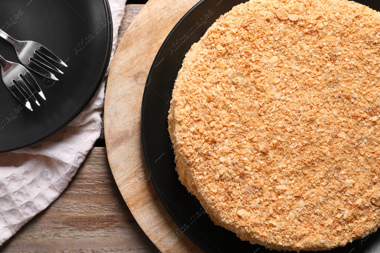 Photo of Delicious Napoleon cake on wooden table, top view