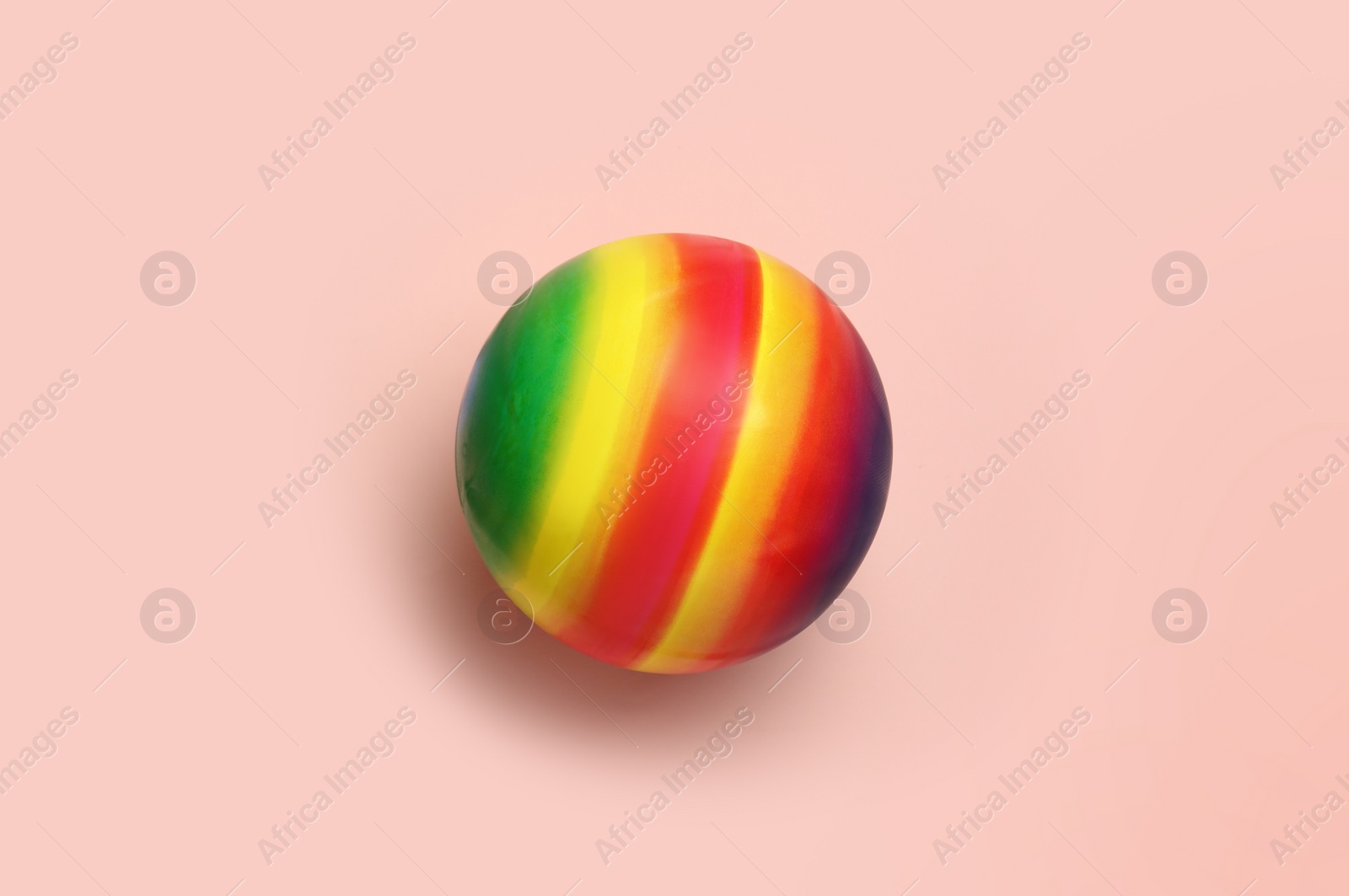 Photo of Bright rubber kids' ball on pink background, top view