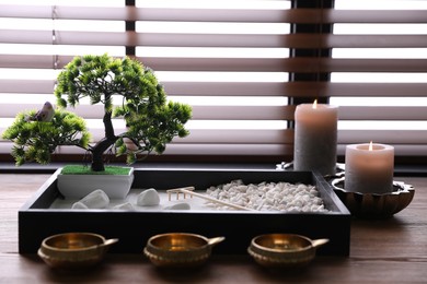 Beautiful miniature zen garden, candles and oil lamps on wooden table