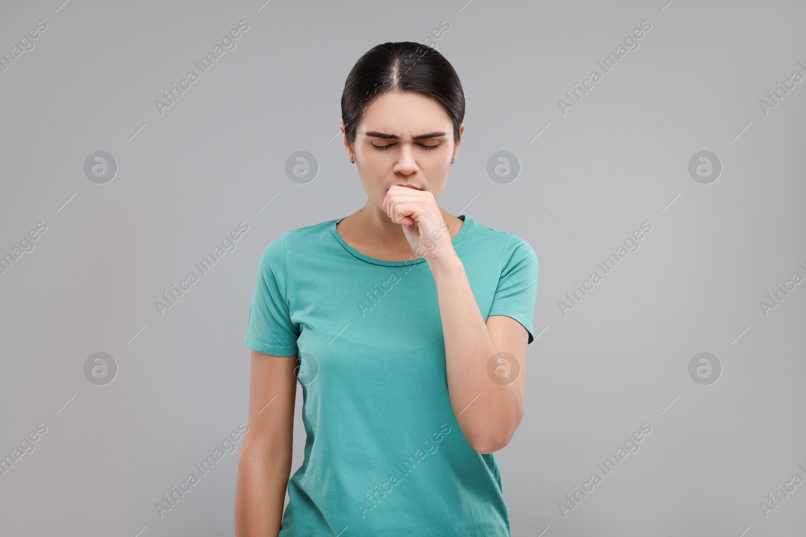 Photo of Woman coughing on grey background. Cold symptoms