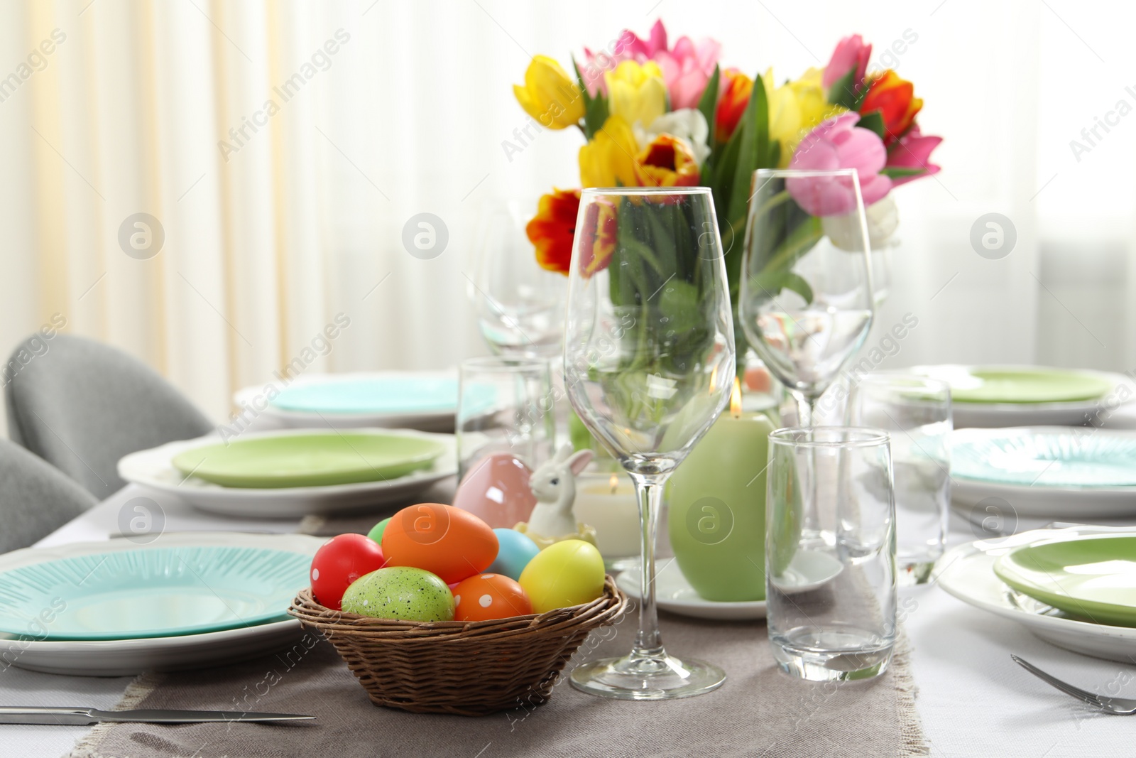 Photo of Easter celebration. Festive table setting with beautiful flowers and painted eggs