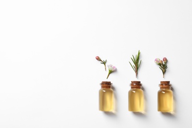 Photo of Flat lay composition with bottles of natural tea tree oil on white background