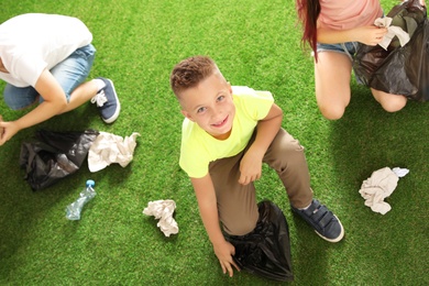 Photo of Children picking up garbage outdoors. Recycling concept