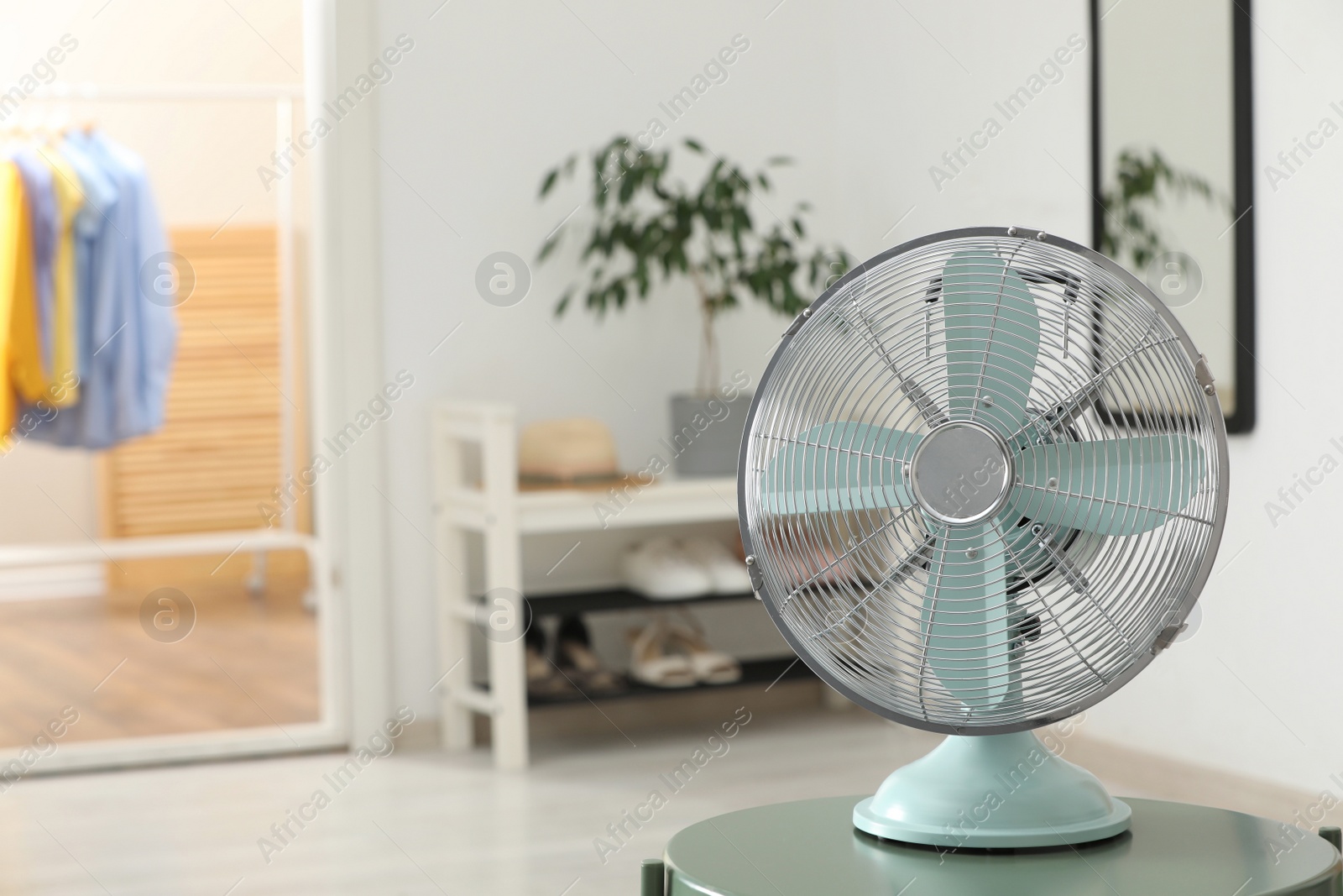 Photo of Modern electric fan on table in room, space for text